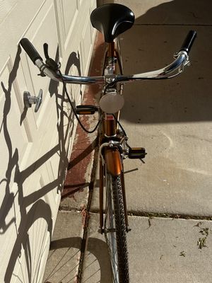 Sale Photo Thumbnail #11: Vintage bronze-toned bicycle featuring upright chrome handlebars, front reflector, and black saddle seat.