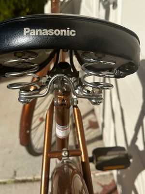 Sale Photo Thumbnail #10: Vintage Panasonic bicycle seat featuring a black vinyl top with white branding and dual chrome under-seat springs.
