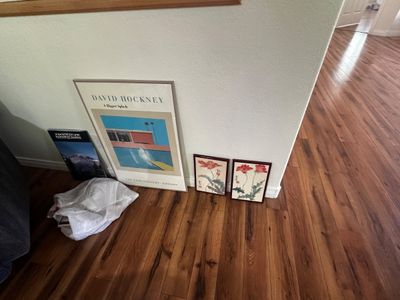 Sale Photo Thumbnail #54: Framed David Hockney 'A Bigger Splash' exhibition poster alongside a pair of small Asian floral art prints leaning against a wall.