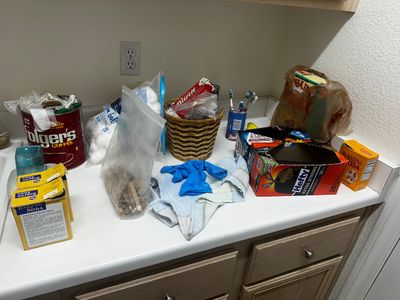 Sale Photo Thumbnail #64: Assortment of household cleaning supplies and bathroom sundries, including baking soda, trash bags, and cotton balls.