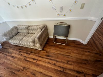 Sale Photo Thumbnail #49: Vintage beige textured chevron-patterned loveseat alongside a set of folding TV tray tables on a brass stand.