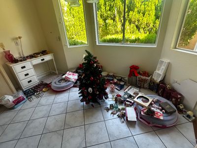 Sale Photo Thumbnail #56: Collection of holiday decorations, small tabletop artificial Christmas tree, ornaments, gift boxes, and assorted household goods displayed on a tiled floor.