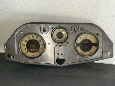 Sale Photo Thumbnail #4: Vintage AC automotive instrument cluster panel featuring a speedometer, amperes gauge, and combined gasoline/oil pressure gauge housed in a stamped metal dashboard bezel.