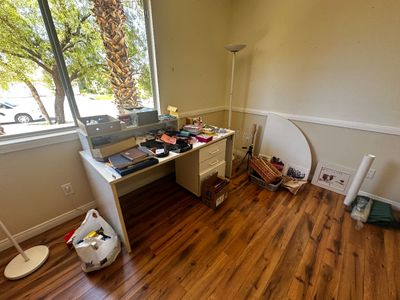 Sale Photo Thumbnail #51: White laminate executive office desk filled with office supplies, books, and miscellaneous household items alongside a white torchier floor lamp.