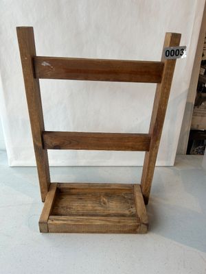 Sale Photo Thumbnail #3: A small handcrafted wooden tabletop display rack with two horizontal crossbars and a recessed base tray. Ideal for displaying small textiles, hand towels, magazines, or decorative items. Constructed from stained wood with visible grain and natural knot de