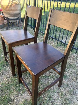 Sale Photo Thumbnail #57: A matching pair of dark stained wood counter-height stools or high-seat chairs featuring straight backs and square stretchers for footrests. Both pieces show light edge wear and scuffs consistent with use.