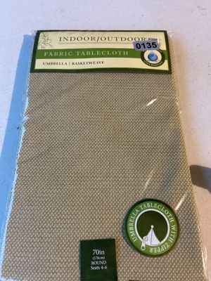 Sale Photo Thumbnail #199: One new in original packaging indoor/outdoor fabric tablecloth in a beige/tan basketweave pattern. Features a zipper for use with patio umbrellas. Measures 70 inches (178 cm) round, suitable for seating 4-6 people. Water and stain resistant.