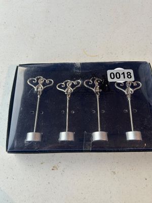 Sale Photo Thumbnail #18: A set of four silver-tone metal place card or photo holders featuring double heart tops with clip grips and small round weighted bases. New in original packaging box.