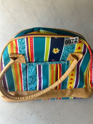 Sale Photo Thumbnail #89: A vibrant, multi-patterned fabric tote bag featuring colorful vertical stripes, floral, and heart motifs in teal, orange, yellow, and purple. Includes faux-leather tan trim, dual shoulder straps, and front exterior slide pockets. Suitable as a travel bag,