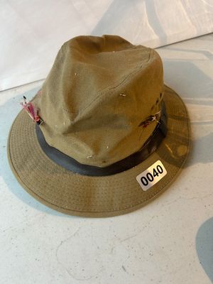 Sale Photo Thumbnail #40: A olive green canvas bucket/fedora style outdoorsman fishing hat featuring a leather band and several decorative fishing flies attached to the hat. Shows light pre-owned wear suitable for age.