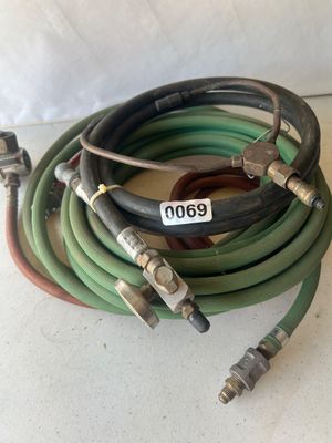 Sale Photo Thumbnail #83: Assorted oxy-acetylene welding/brazing hoses and a red Turbo-Torch handle featuring brass fittings, valve adjustments, and connection couplers. Show signs of age and wear consistent with previous shop or job-site use.