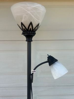 Sale Photo Thumbnail #65: Black metal torchiere floor lamp featuring an upper main light with a marbled white frosted glass shade, decorative crown motif detail, and an attached adjustable gooseneck reading light with a matching shade. Round decorative heavy base with floral scrol