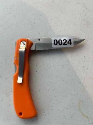Sale Photo Thumbnail #24: A compact folding pocket knife featuring a bright orange composite handle, a metal belt/pocket clip, and a partially serrated stainless steel blade.