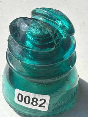Sale Photo Thumbnail #104: A vintage Hemingray teal/green glass insulator featuring a saddle top design. Marked 'HEMINGRAY' near the base. Appears to be in good vintage condition with minor surface wear consistent with age and use.