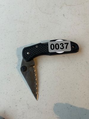 Sale Photo Thumbnail #37: Small folding pocket knife featuring a partially serrated stainless steel blade, textured black handle with lanyard hole, and thumb stud for easy opening. Shows light wear from prior use.