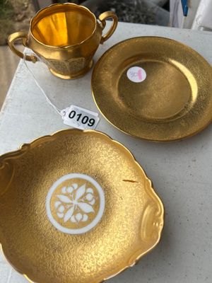 Sale Photo Thumbnail #167: A set of vintage gold-encrusted porcelain table service items including a two-handled sugar bowl stamped Pickard, Decorated in U.S.A. (number 499), a small bowl with a floral central motif labeled Wheeling Decorating Glass China, and a matching gold etche