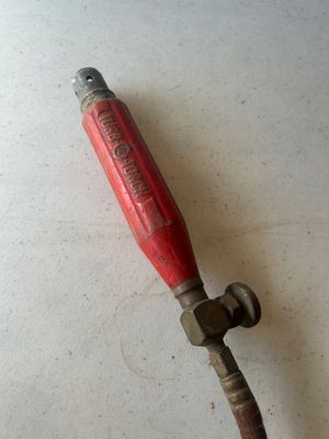Sale Photo Thumbnail #85: Assorted oxy-acetylene welding/brazing hoses and a red Turbo-Torch handle featuring brass fittings, valve adjustments, and connection couplers. Show signs of age and wear consistent with previous shop or job-site use.