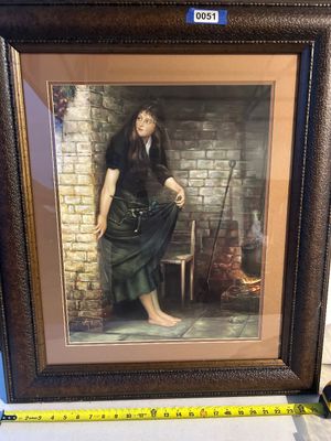 Sale Photo Thumbnail #51: A large framed art print depicting a barefoot young woman in Victorian-style attire gathering twigs by a brick hearth or fireplace. Housed in a dark textured composite wood frame with double matting. Measures approximately 25 inches wide at the base.