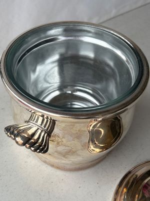 Sale Photo Thumbnail #169: A vintage silver-plated ice bucket or covered serving dish made by Wm. Rogers (marked 27 on bottom). Features shell-motif side handles, a removable lid with a fluted finial, and a clear glass interior liner. Exhibits light surface tarnish and age-appropri
