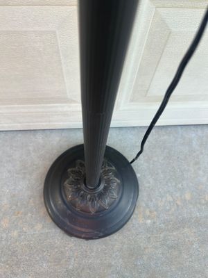 Sale Photo Thumbnail #66: Black metal torchiere floor lamp featuring an upper main light with a marbled white frosted glass shade, decorative crown motif detail, and an attached adjustable gooseneck reading light with a matching shade. Round decorative heavy base with floral scrol