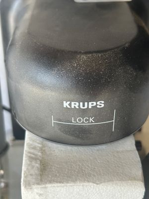 Sale Photo Thumbnail #116: Krups black countertop espresso/cappuccino maker, complete with glass carafe, filter holder, and steam wand. Features a steam cap safety lock. Item comes partially packed in original Styrofoam packaging. Lot tag 0088 attached.
