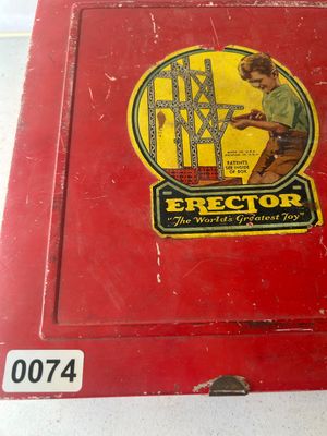 Sale Photo Thumbnail #93: A vintage A.C. Gilbert Erector Set No. 8 1/2 "All-Electric" construction toy set housed in its original red metal carrying case. The set includes various metal girders, plates, wheels, pulleys, and electric motor/engine units along with original lid graph