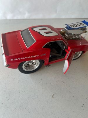 Sale Photo Thumbnail #149: A red custom cartoon-styled/hot rod die-cast model car featuring Dale Earnhardt Jr. #8 graphics, a large exposed blower/engine intake, opening doors, and oversized deep-dish rear wheels. Shows minor wear and dust consistent with display.