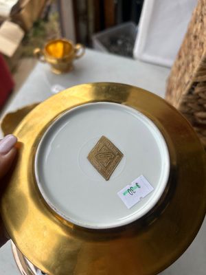 Sale Photo Thumbnail #165: A set of vintage gold-encrusted porcelain table service items including a two-handled sugar bowl stamped Pickard, Decorated in U.S.A. (number 499), a small bowl with a floral central motif labeled Wheeling Decorating Glass China, and a matching gold etche
