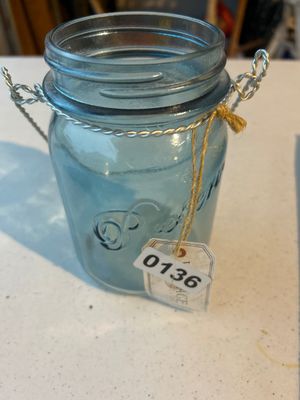Sale Photo Thumbnail #200: A light blue translucent glass canning/preserve jar featuring embossed lettering ("Preserve") on the side and a twisted wire bail handle around the neck. Appears to be in good vintage condition with no visible chips or cracks. Tagged with lot label 0136.