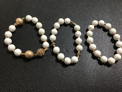Sale Photo Thumbnail #116: Set of three elastic stretch bracelets featuring smooth matte white beads, gold-tone square spacers, textured gold-tone accent beads, and sparkling crystal rhinestone details. Appears to be in good, pre-owned condition with no missing stones visible.