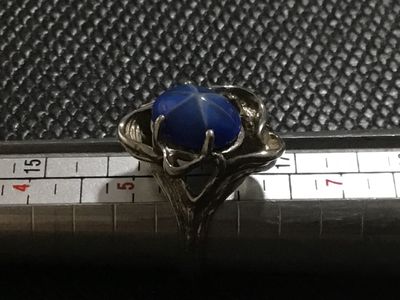 Sale Photo Thumbnail #131: Vintage statement ring featuring an oval cabochon blue star sapphire (asterism evident) set in an ornate, textured white gold mounting. Stamped '' inside the band alongside a maker's mark. Ring size measures approximately 5.5 - 5.75 on mandrel. Pre-owned 