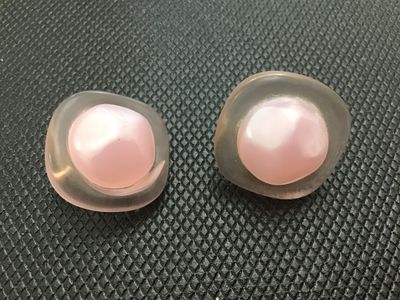 Sale Photo Thumbnail #20: Pair of vintage clip-on earrings featuring frosted soft pink lucite frames set with central iridescent pink pearlescent cabochons. Gold-tone clip mechanisms. Items show light wear consistent with age, clip mechanisms function properly.