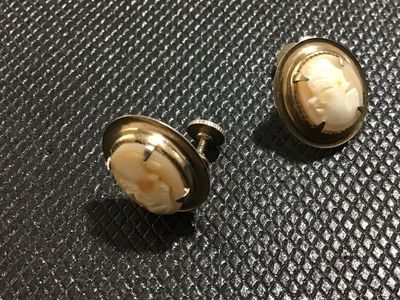 Sale Photo Thumbnail #129: Pair of vintage oval shell cameo earrings featuring carved female profile portraits set in gold-tone metal frames with screw-back closures for non-pierced ears. Good vintage condition with light wear consistent with age.