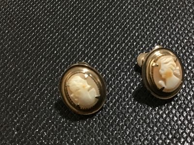 Sale Photo Thumbnail #126: Pair of vintage oval shell cameo earrings featuring carved female profile portraits set in gold-tone metal frames with screw-back closures for non-pierced ears. Good vintage condition with light wear consistent with age.