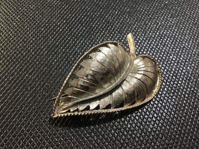 Sale Photo Thumbnail #93: A vintage gold-tone leaf brooch by BSK featuring a textured brushed metal finish, curved stem detail, and a rope twist border. The back is stamped '©BSK' and includes a standard pin stem with a rollover safety clasp. Shows light vintage wear consistent w