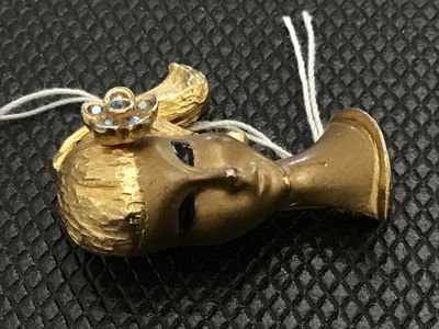 Sale Photo Thumbnail #5: Vintage Crown Trifari gold-tone costume jewelry brooch depicting a stylized woman's bust or head with a ponytail, painted black eyes, and a floral hair piece set with iridescent rhinestones. Marked on the back with the Crown Trifari logo. Pin mechanism is