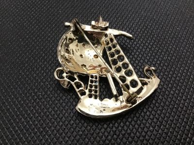 Sale Photo Thumbnail #27: Vintage nautical sailing ship brooch pin featuring white, light blue, and black enamel accents with clear rhinestone details set in gold-tone metal. Standard pin stem and safety clasp on the reverse. Shows minor wear to the enamel and finish consistent wi