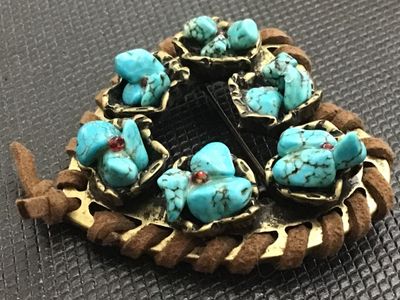 Sale Photo Thumbnail #17: Southwestern style heart-shaped brooch featuring brass-tone metal wrapped with brown suede cord trim. Decorated with clusters of faux turquoise stones accented with small red rhinestones. Includes a standard rollover safety clasp pin back. Good vintage co