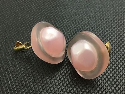 Sale Photo Thumbnail #18: Pair of vintage clip-on earrings featuring frosted soft pink lucite frames set with central iridescent pink pearlescent cabochons. Gold-tone clip mechanisms. Items show light wear consistent with age, clip mechanisms function properly.