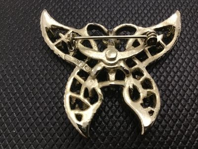 Sale Photo Thumbnail #22: A vintage gold-tone metal butterfly brooch featuring textured rope-like openwork wings accented with blue painted highlights. Includes a standard roll-over safety clasp pin mechanism on the back. Shows light surface wear consistent with age.