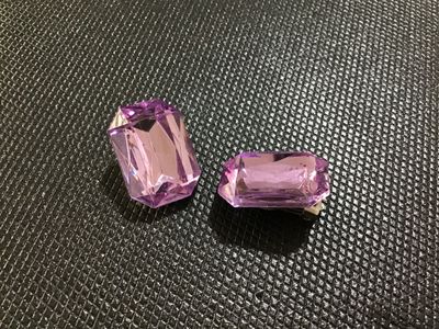 Sale Photo Thumbnail #58: Pair of vintage clip-on costume earrings featuring large emerald-cut purple faceted faux /rhinestone focal stones mounted on silver-tone metal clip backs. Good vintage condition with light wear on the metal backs.