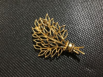 Sale Photo Thumbnail #81: Vintage gold-tone brooch featuring an intricate openwork leaf spray or bouquet motif with textured and beaded detailing. Marked 'Lisner on the reverse side. Secured with a standard pin stem and rollover safety clasp. Shows light vintage wear appropriate f