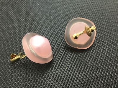 Sale Photo Thumbnail #19: Pair of vintage clip-on earrings featuring frosted soft pink lucite frames set with central iridescent pink pearlescent cabochons. Gold-tone clip mechanisms. Items show light wear consistent with age, clip mechanisms function properly.