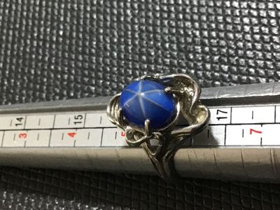 Sale Photo Thumbnail #130: Vintage statement ring featuring an oval cabochon blue star sapphire (asterism evident) set in an ornate, textured white gold mounting. Stamped '' inside the band alongside a maker's mark. Ring size measures approximately 5.5 - 5.75 on mandrel. Pre-owned 