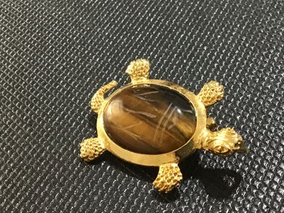 Sale Photo Thumbnail #59: Gold-tone turtle motif pin/brooch featuring a carved or etched tiger's eye cabochon shell. Includes a bail on the back so it can also be worn as a necklace pendant. Gold finish shows light surface wear/aging. Pin mechanism on back is intact and functional