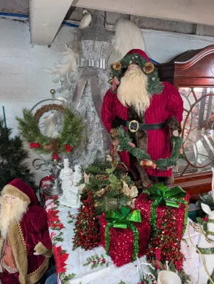Sale Photo Thumbnail #55: Collection of Christmas decorations: tabletop Santa figures, tinsel present props & a silver wire dress form tree.