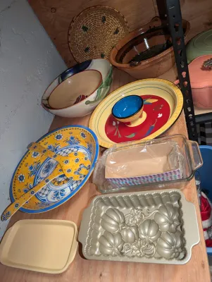 Sale Photo Thumbnail #19: Collection of kitchenware including vibrant ceramic serving bowls with wooden servers, a Nordic Ware pumpkin loaf pan, glass baking dish. 