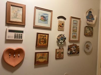 Sale Photo Thumbnail #28: Collection of framed vintage wall art and decorative wall plaques featuring Winnie the Pooh, Eeyore, and rustic country motifs.