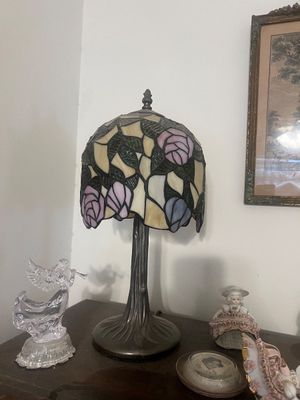 Sale Photo Thumbnail #23: Tiffany-style stained glass table lamp featuring a floral rose pattern shade on a tree trunk-formed metal base.