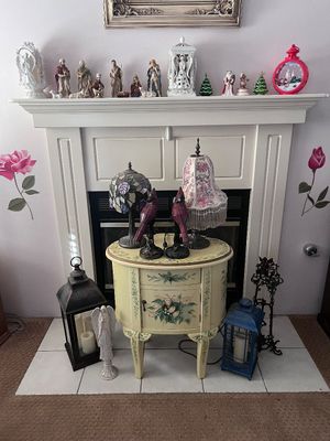 Sale Photo Thumbnail #20: Hand-painted cream accent table displaying lamps and cardinal figurines, set in front of a fireplace with holiday décor on the mantel.